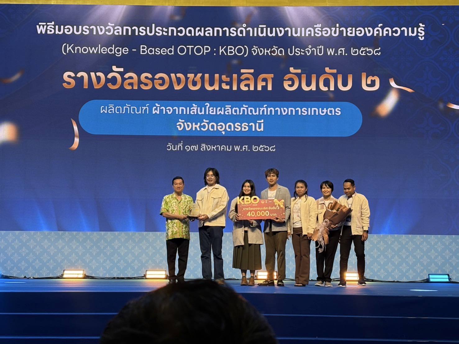 ผู้ประกอบการ OTOP เจ้าของผลิตภัณฑ์กลุ่มวิสาหกิจชุมชนสิ่งทอเศรษฐกิจหมุนเวียนบ้านดงเรือง ตำบลผาสุก อำเภอกุมภวาปี จังหวัดอุดรธานี คว้ารางวัล รองชนะเลิศอันดับ 2 การประกวดผลการดำเนินงานเครือข่ายองค์ความรู้ (Knowledge - Based OTOP : KBO) จังหวัด ประจำปี พ.ศ.2568 ของกรมการพัฒนาชุมชน